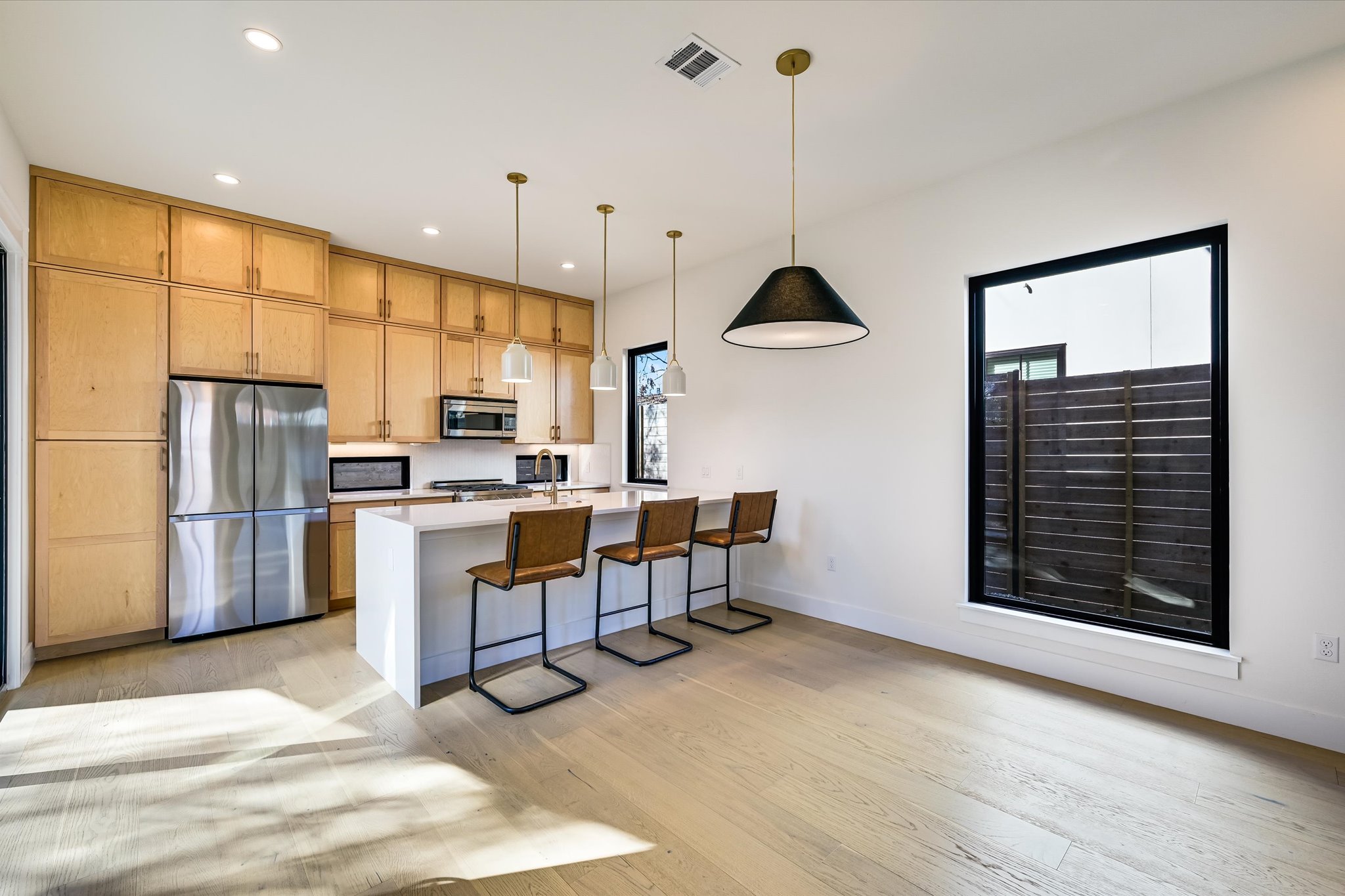 3503 Kay Street, Unit 2 Austin, TX 78702 - Photo 6 of 19 a kitchen with stainless steel appliances granite countertop a refrigerator a stove a sink dishwasher and white cabinets with wooden floor