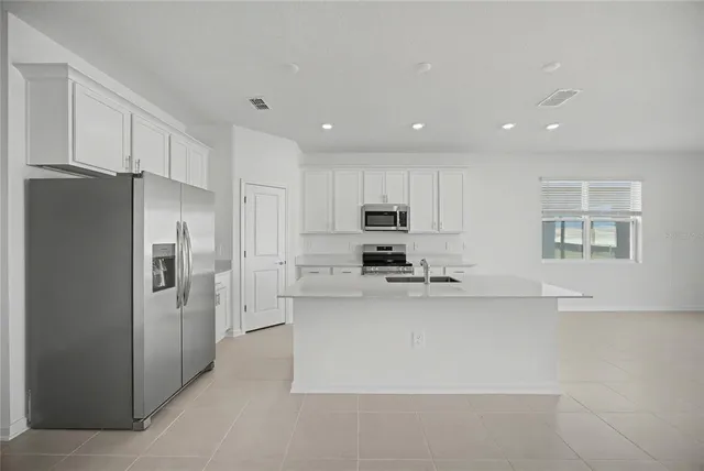 a kitchen with stainless steel appliances a refrigerator a stove a sink a microwave and cabinets
