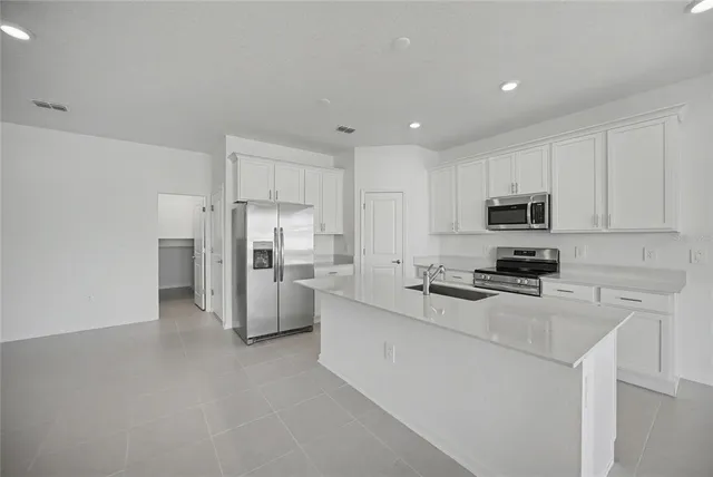 a kitchen with stainless steel appliances a refrigerator and a stove top oven
