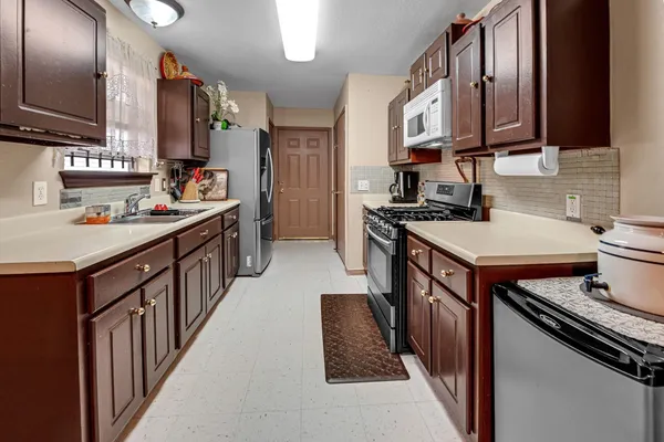 a kitchen with a stove sink and cabinets