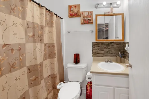a bathroom with a sink a toilet and a mirror