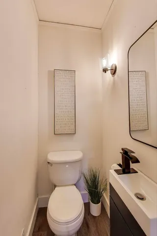 a white toilet sitting next to a bathroom sink and vanity