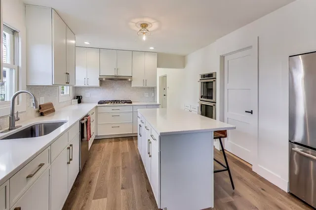 a kitchen with a sink a counter top space stainless steel appliances and cabinets