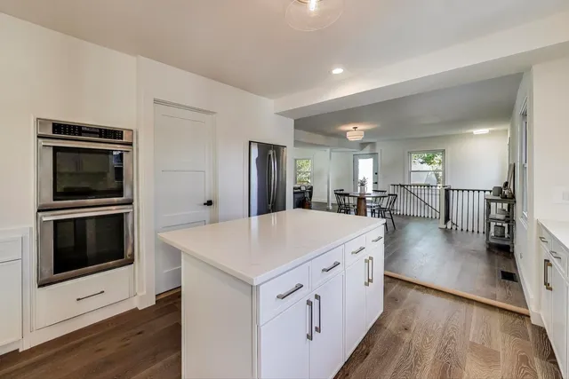 a large white kitchen with a stove top oven