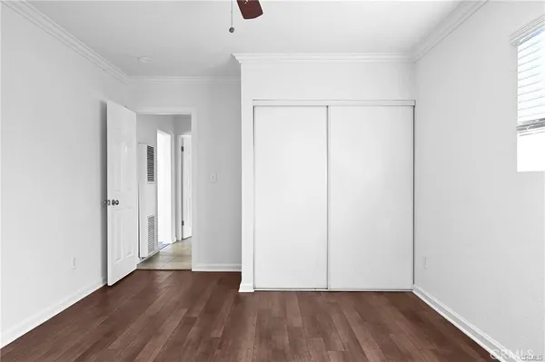 an empty room with wooden floor and a window