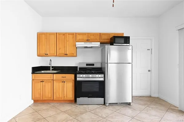 a kitchen with stainless steel appliances granite countertop a refrigerator and a stove