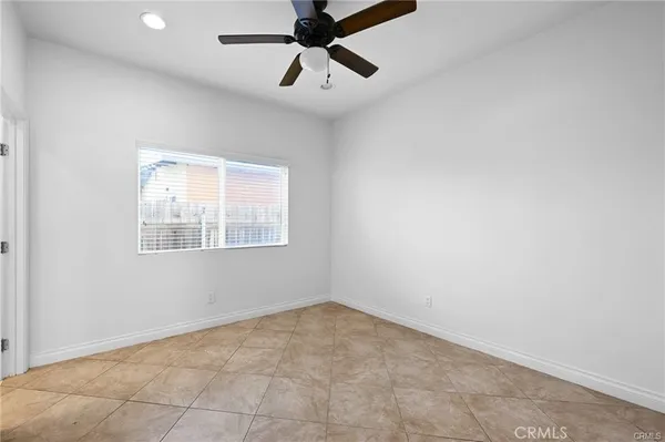 an empty room with a window and a fan