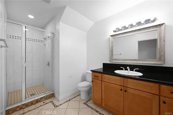 a bathroom with a granite countertop sink toilet mirror and shower