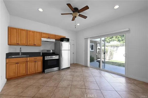 a kitchen with granite countertop a refrigerator and a sink