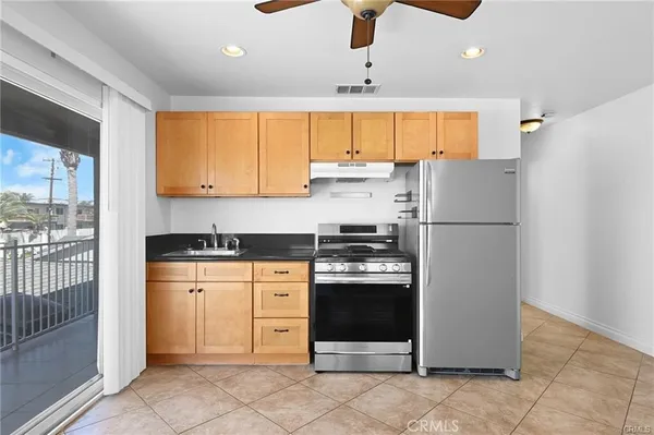 a kitchen with stainless steel appliances granite countertop a refrigerator and a stove top oven