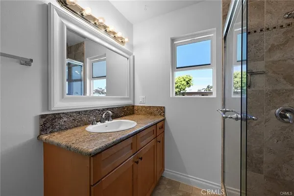 a bathroom with a granite countertop sink and a mirror