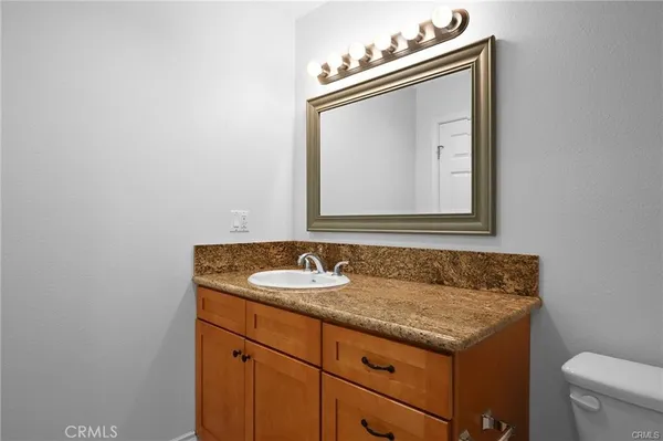 a bathroom with a granite countertop sink and a mirror