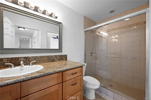 a bathroom with a granite countertop sink toilet and shower