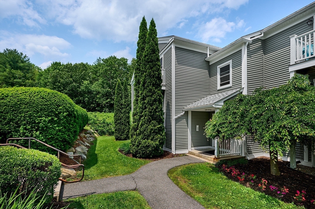 48 Evergreen Road, Unit 312 Leeds, MA 01053 - Photo 3 of 22 a front view of a house with a yard and trees