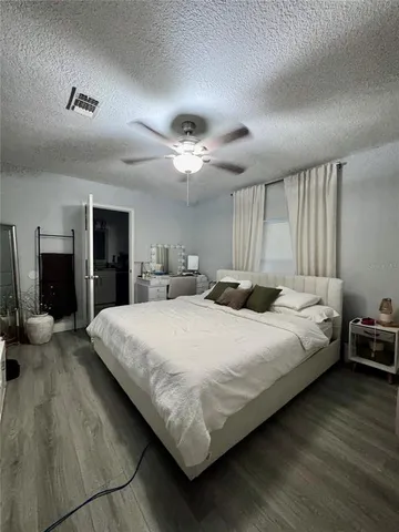 a large bed sitting in a bedroom and a chandelier