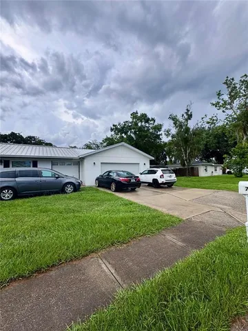 a car parked in front of a house next to a yard
