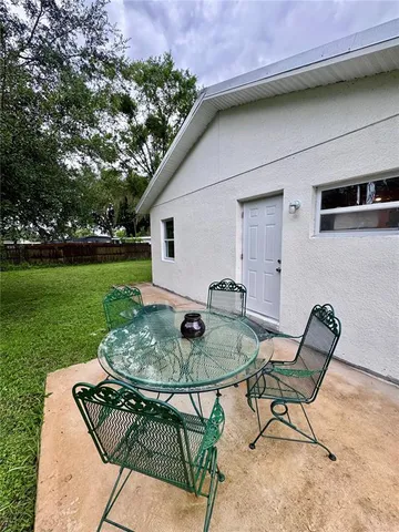 a backyard of a house with table and chairs