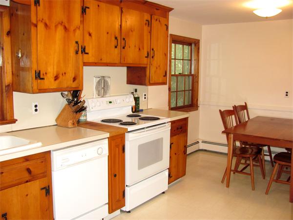 50 Clearwater Road Brookline, MA 02467 - Photo 5 of 16 a kitchen with a stove a sink cabinets and a dining table