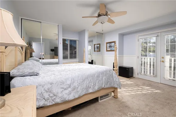 a spacious bedroom with a large bed and a chandelier
