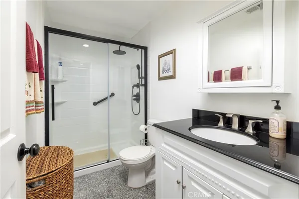 a bathroom with a granite countertop sink toilet and shower