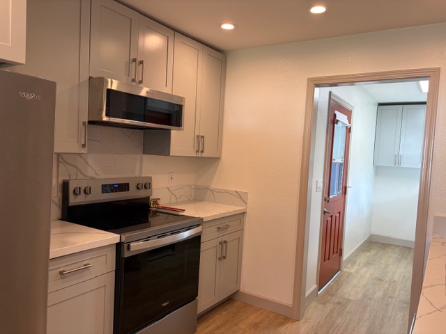 856 Ho'olala Place Hilo, HI 96720 - Photo 17 of 30 a kitchen with stainless steel appliances granite countertop a stove and a refrigerator