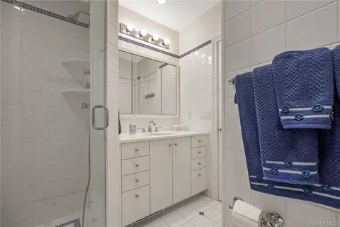 a spacious bathroom with a double vanity sink a mirror and a shower
