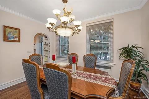 a dining room with furniture potted plants and wooden floor