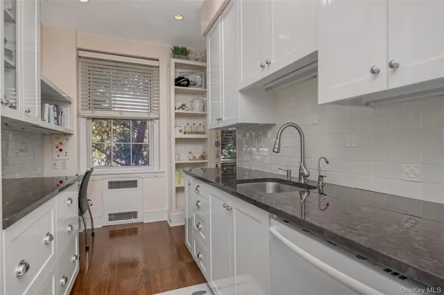 a kitchen with granite countertop a sink stainless steel appliances and cabinets