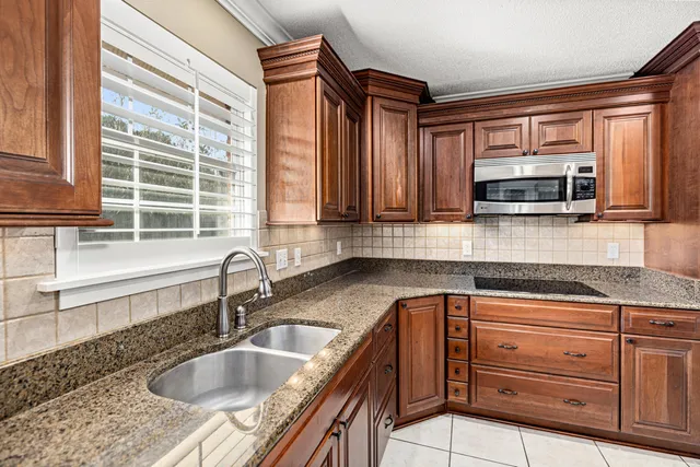 a kitchen with granite countertop a sink and a microwave