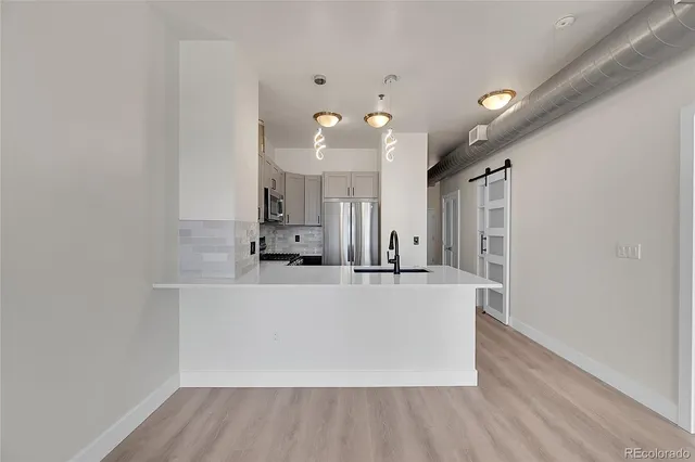 a large white kitchen with wooden floors and white walls