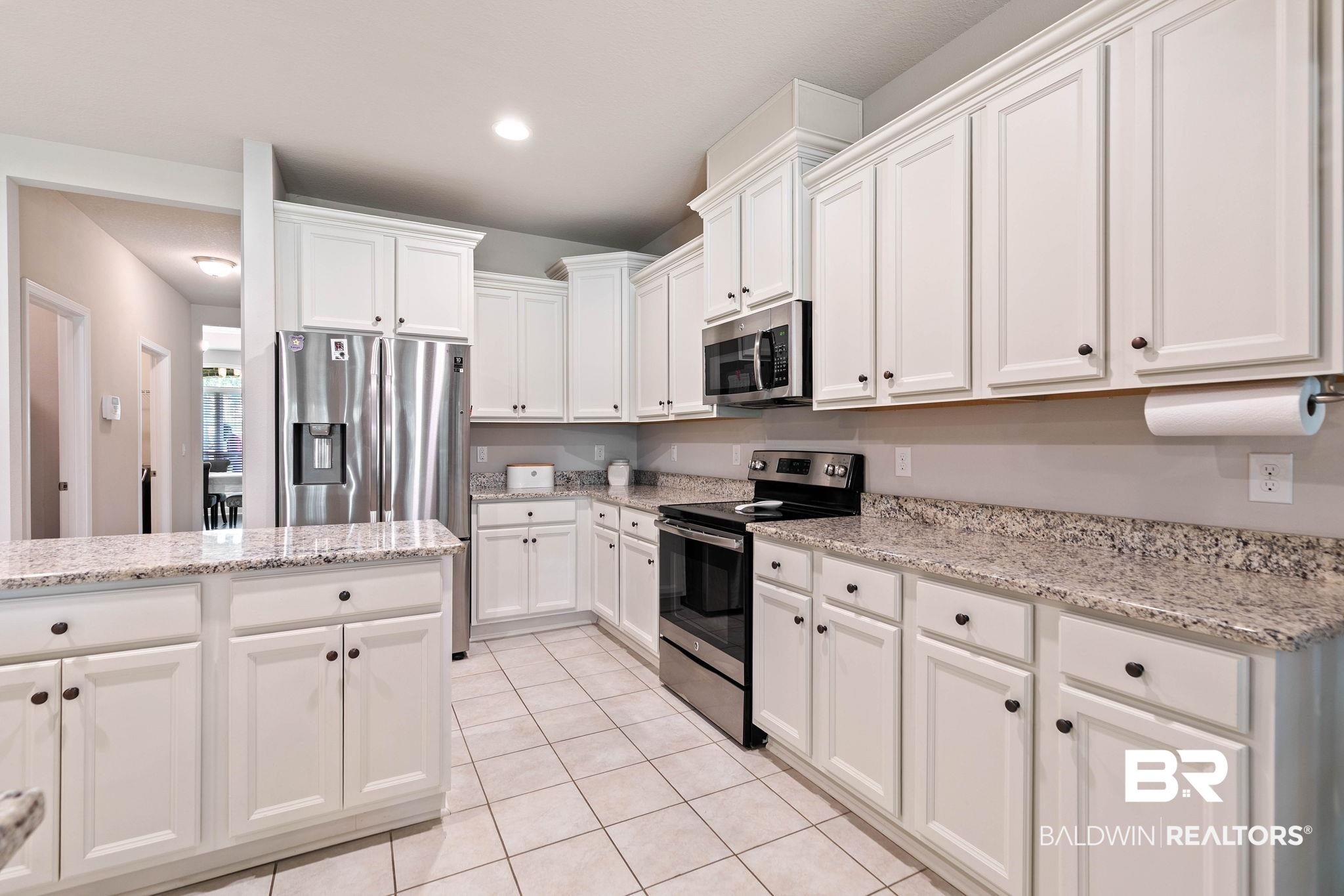 12750 B Jenkins Pit Road Daphne, AL 36527 - Photo 22 of 89 Kitchen featuring stainless steel appliances, white cabinetry, light stone counters, light tile patterned floors, and recessed lighting