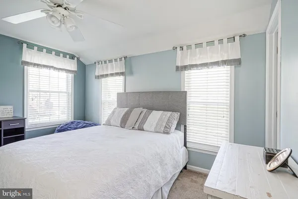 a bedroom with a bed a chandelier and a dresser