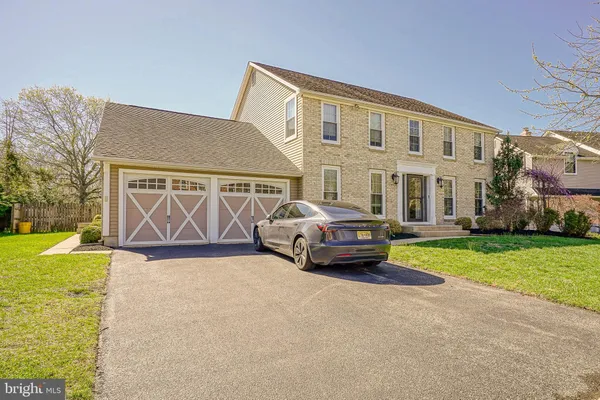 a car parked in front of a house with a garden