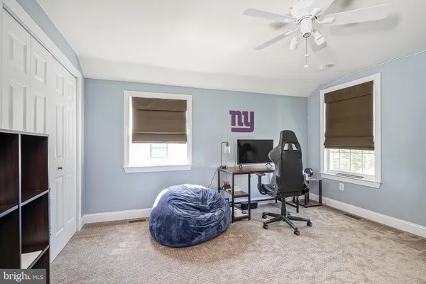 a view of a workspace with furniture and a window