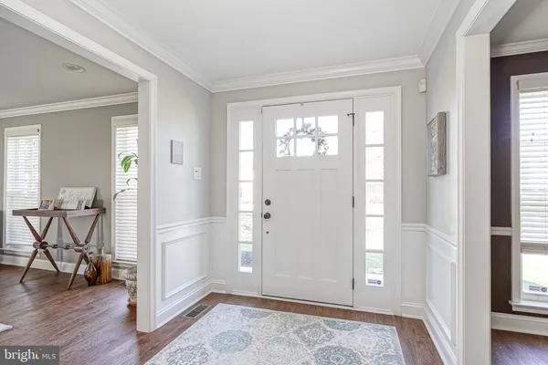 a view of an empty room and bedroom with wooden floor and windows