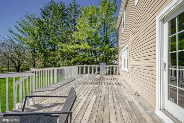 a balcony with wooden floor next to a yard