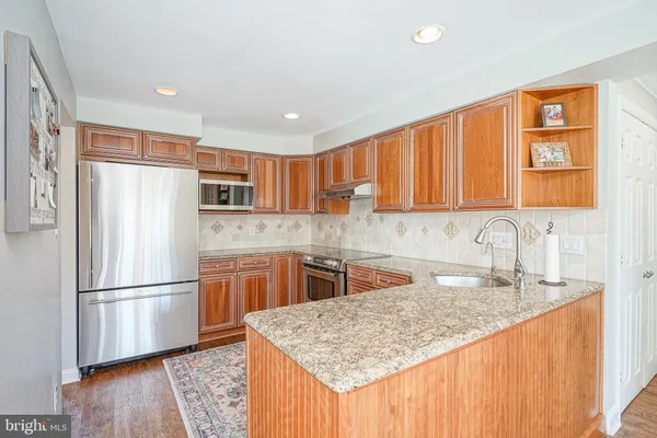 a kitchen with stainless steel appliances granite countertop a refrigerator sink and cabinets