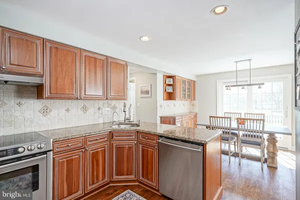 a kitchen with granite countertop a stove top oven sink and cabinets