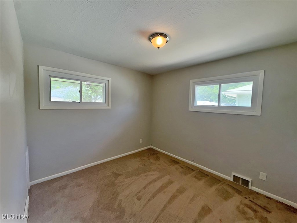 28642 Forest Road Willowick, OH 44095 - Photo 17 of 23 Unfurnished room featuring healthy amount of natural light, light colored carpet, and a textured ceiling