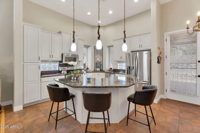 a kitchen with stainless steel appliances kitchen island granite countertop a stove a sink and a living room view
