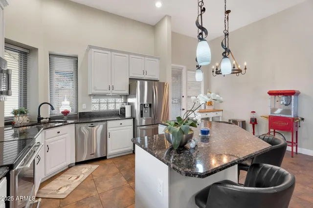 a dining room with wooden floor a chandelier a glass table and windows