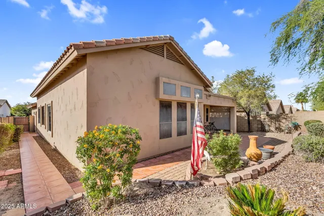 a front view of a house with a yard and potted plants