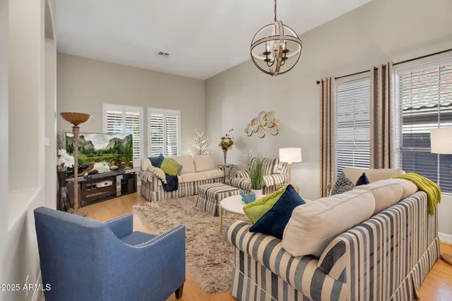 a kitchen with stainless steel appliances granite countertop a sink dishwasher a stove a refrigerator a dining table and chairs with wooden floor