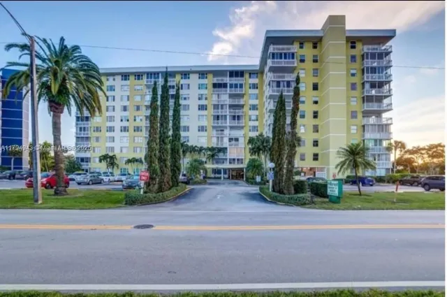 a view of a tall building next to a yard