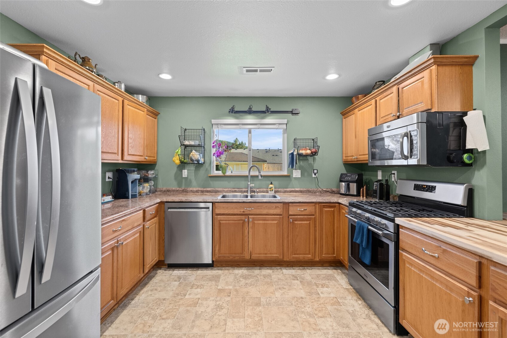 415 Sterling Street Sedro-Woolley, WA 98284 - Photo 18 of 38 a kitchen with stainless steel appliances granite countertop a refrigerator and a stove top oven