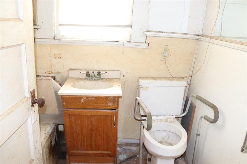 417 North Scullin Avenue Denison, TX 75020 - Photo 5 of 16 a bathroom with a toilet sink and mirror