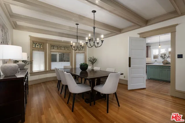 a kitchen with a stove a refrigerator and a dining table with wooden floor