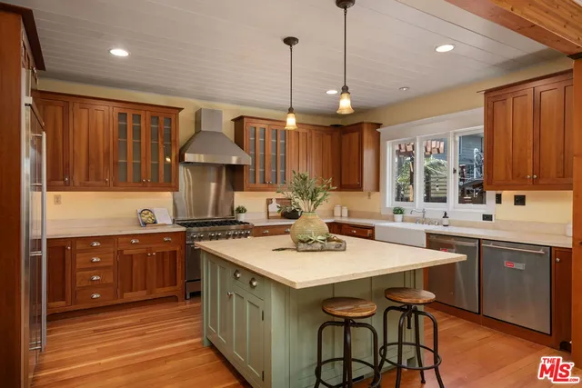 a dining room with wooden floor a chandelier a wooden table and chairs