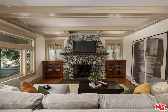 a living room with furniture a fireplace and a flat screen tv