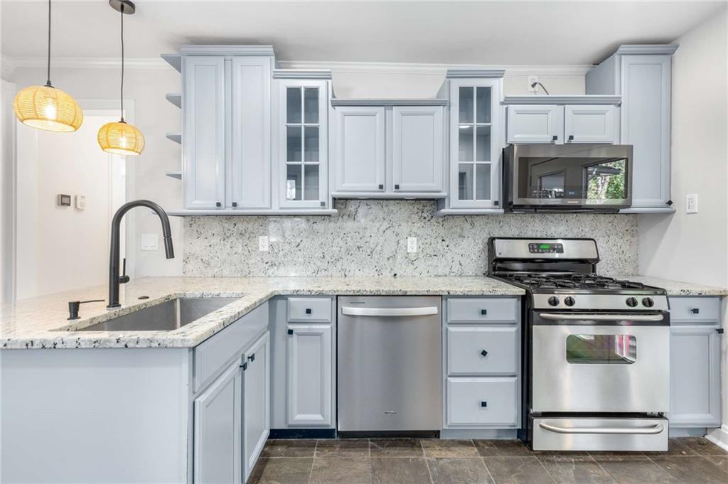 216 Haralson Avenue Northeast Atlanta, GA 30307 - Photo 15 of 34 a kitchen with white cabinets stainless steel appliances and sink